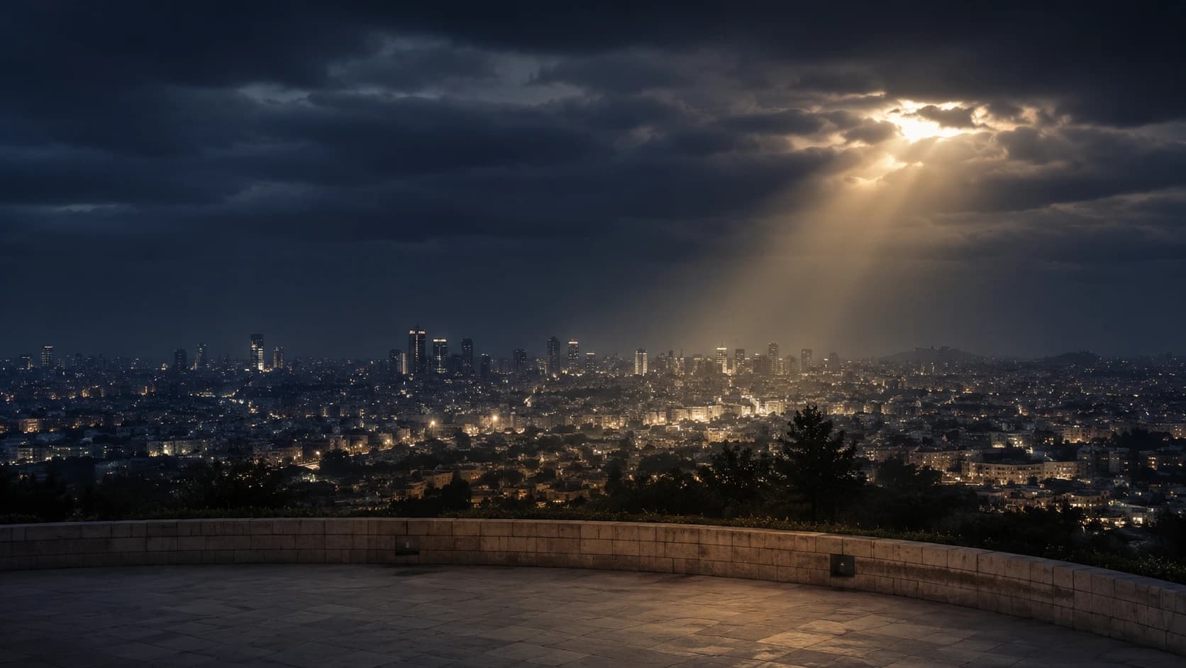 Cidade observada à noite sob um céu carregado e uma abertura de luz